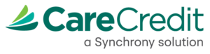 Logo of CareCredit, featuring green stylized text and abstract design. Includes tagline "a Synchrony solution" beneath. No people or buildings present.